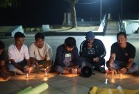 Para jurnalis saat menggelar doa dan membakar lilin di Landmark Kota Ternate. (Kredit Foto: Aji Ternate/Istimewa)